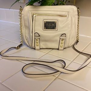 Cream small crossbody purse with gold chain, studs, and detail